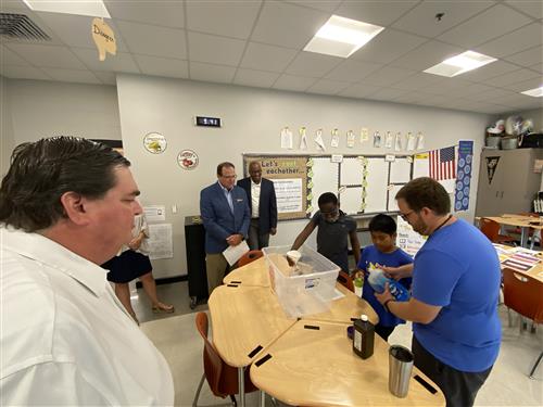 Board member Greg Hulsey with Superintendent Ed Nichols and Board member Travis Cummings watching student experiment